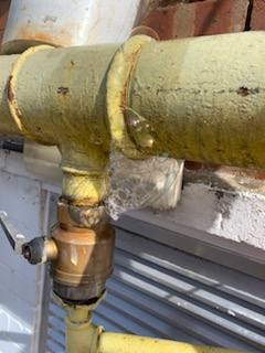Leak detection fluid bubbling at a joint on external yellow gas pipework